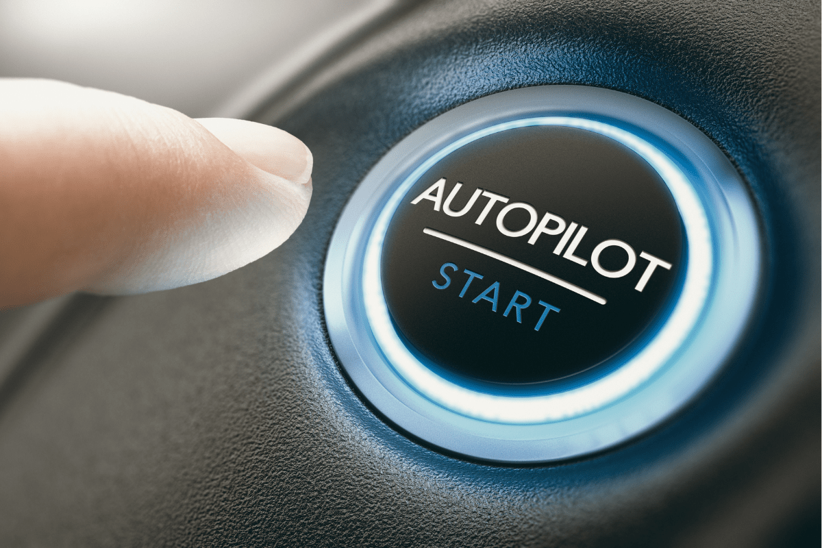 Finger about to press a glowing "Autopilot Start" button on a dashboard.