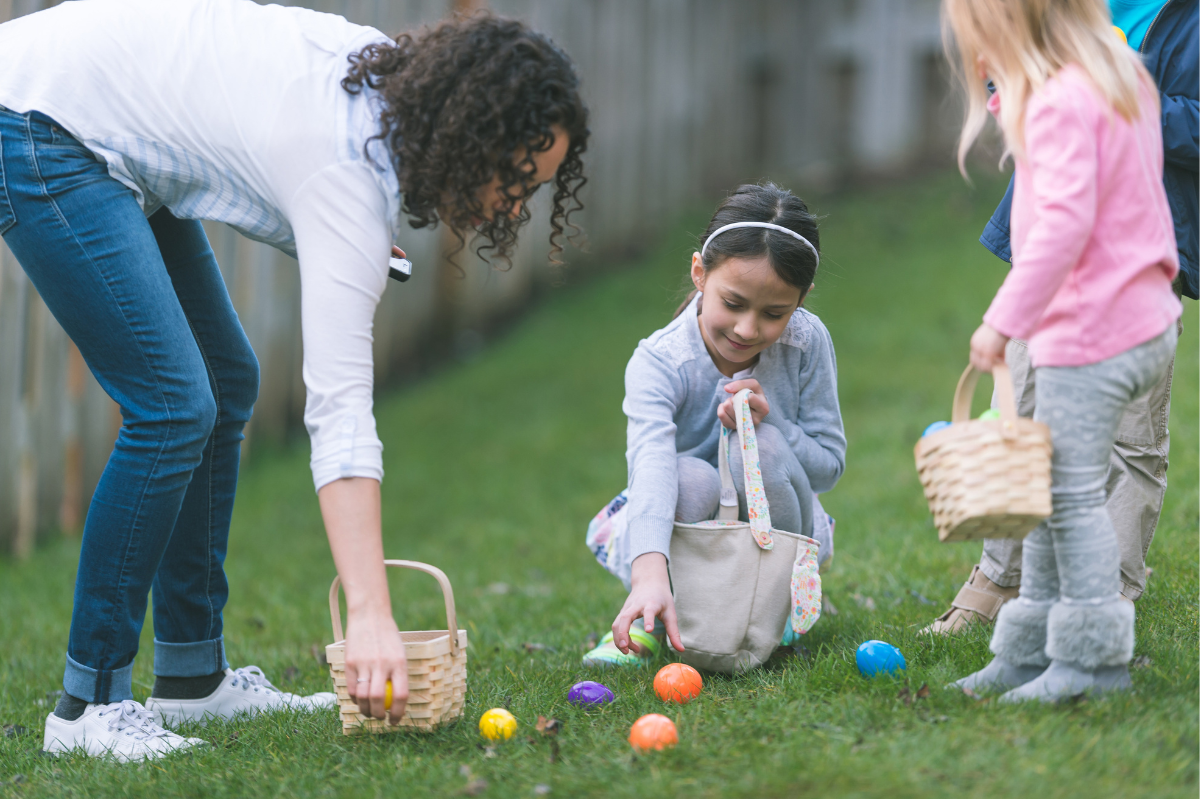 Kids collecting colorful Easter eggs in a garden with baskets.