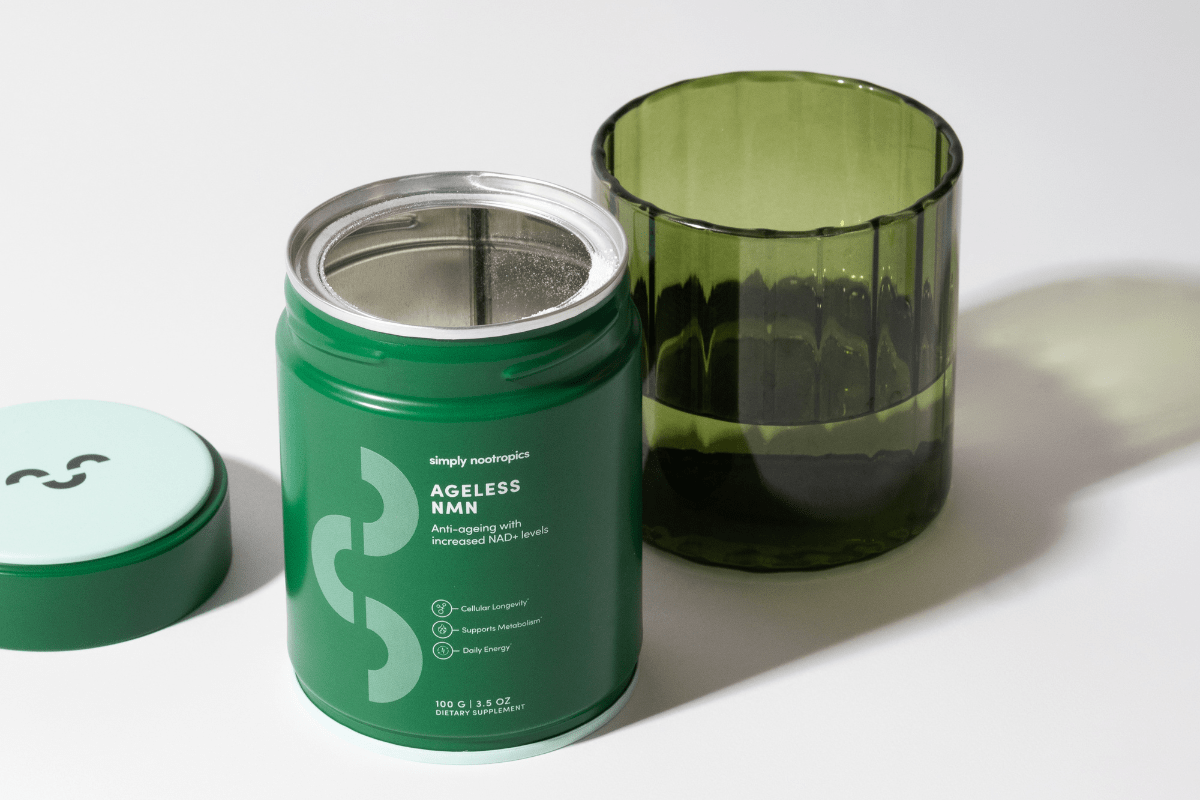 Simply Nootropics Ageless NMN supplement tin next to a green glass of water.