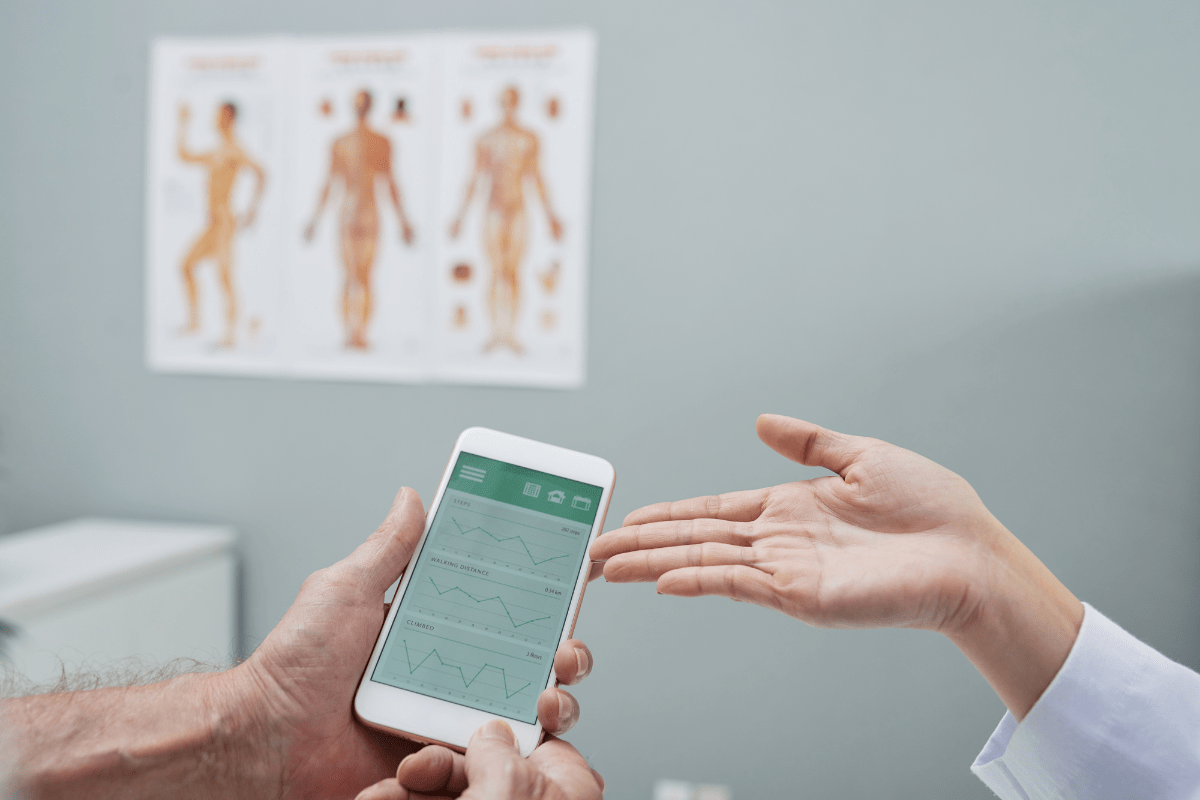 A person holding a smartphone displaying health tracking graphs.
