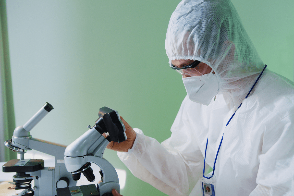 Scientist examines samples under a microscope in a laboratory.
