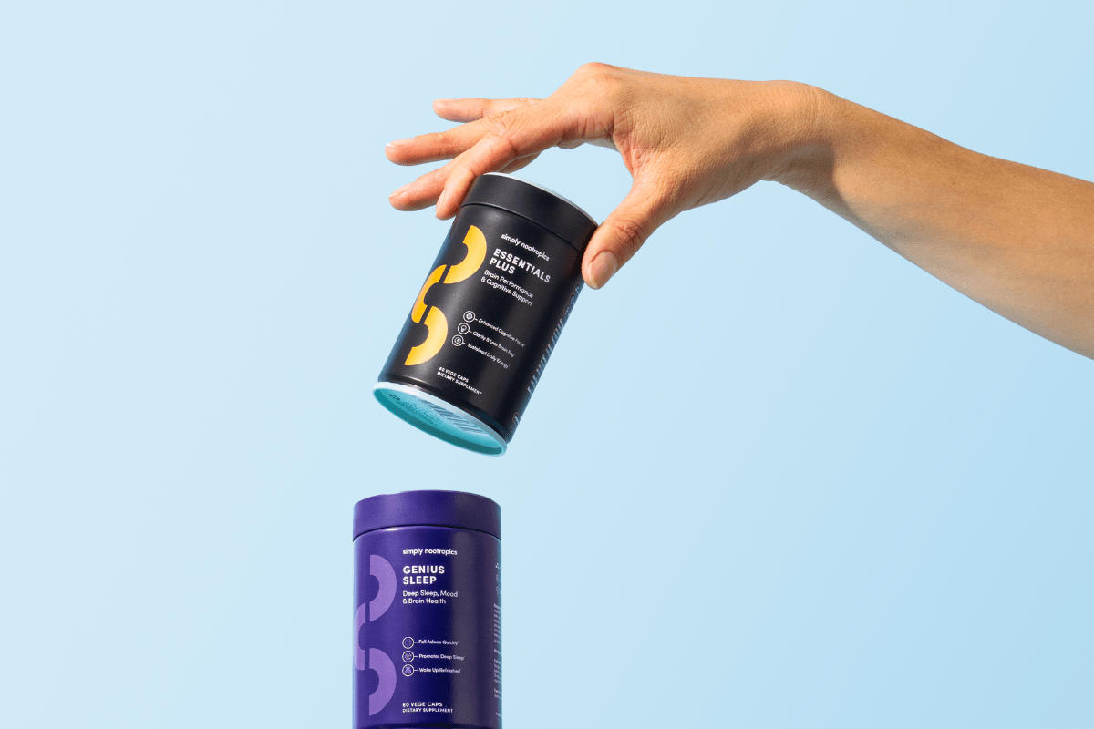Hand holding Simply Nootropics Essentials Plus above a Genius Sleep bottle.