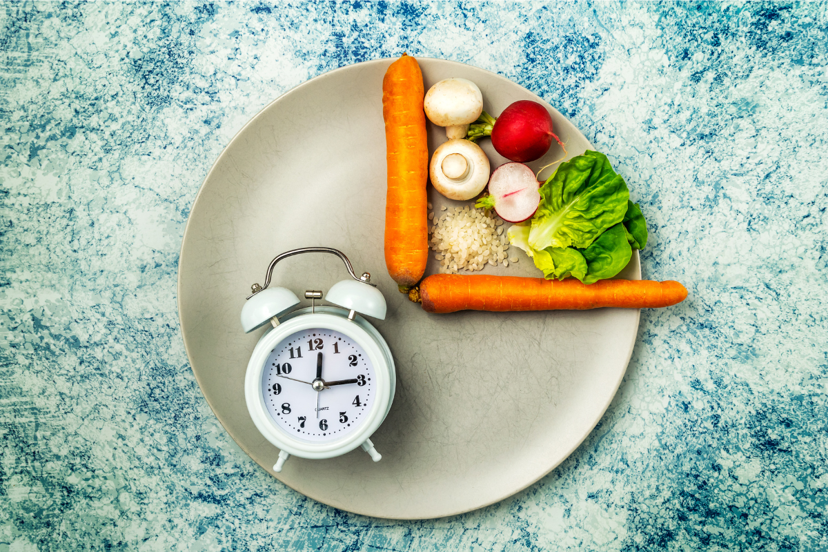 A plate with vegetables and rice arranged to form the shape of a clock, symbolising the concept of intermittent fasting.