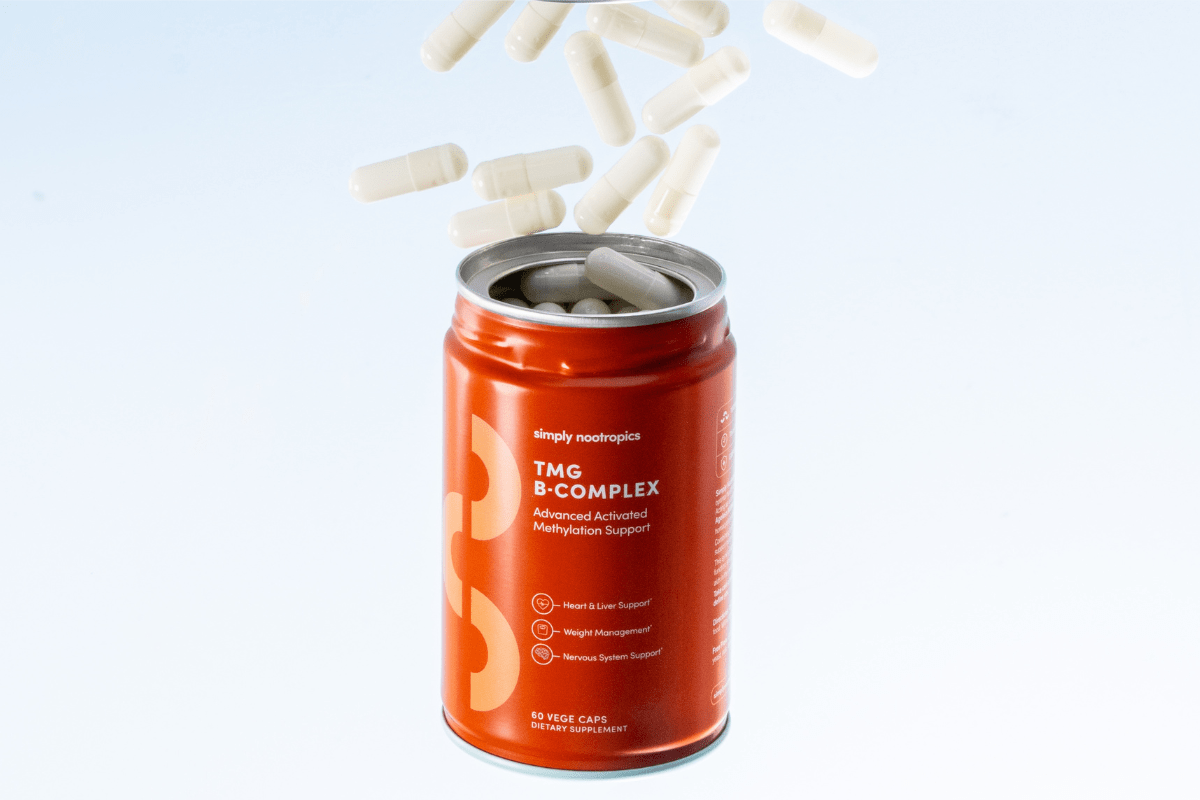 TMG B-Complex supplement capsules spilling from container.