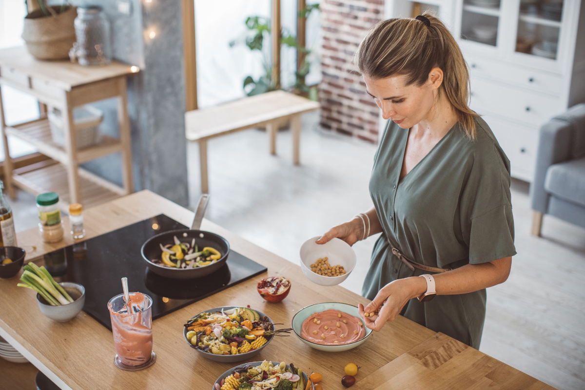 Woman preparing a healthy meal in a bright kitchen.