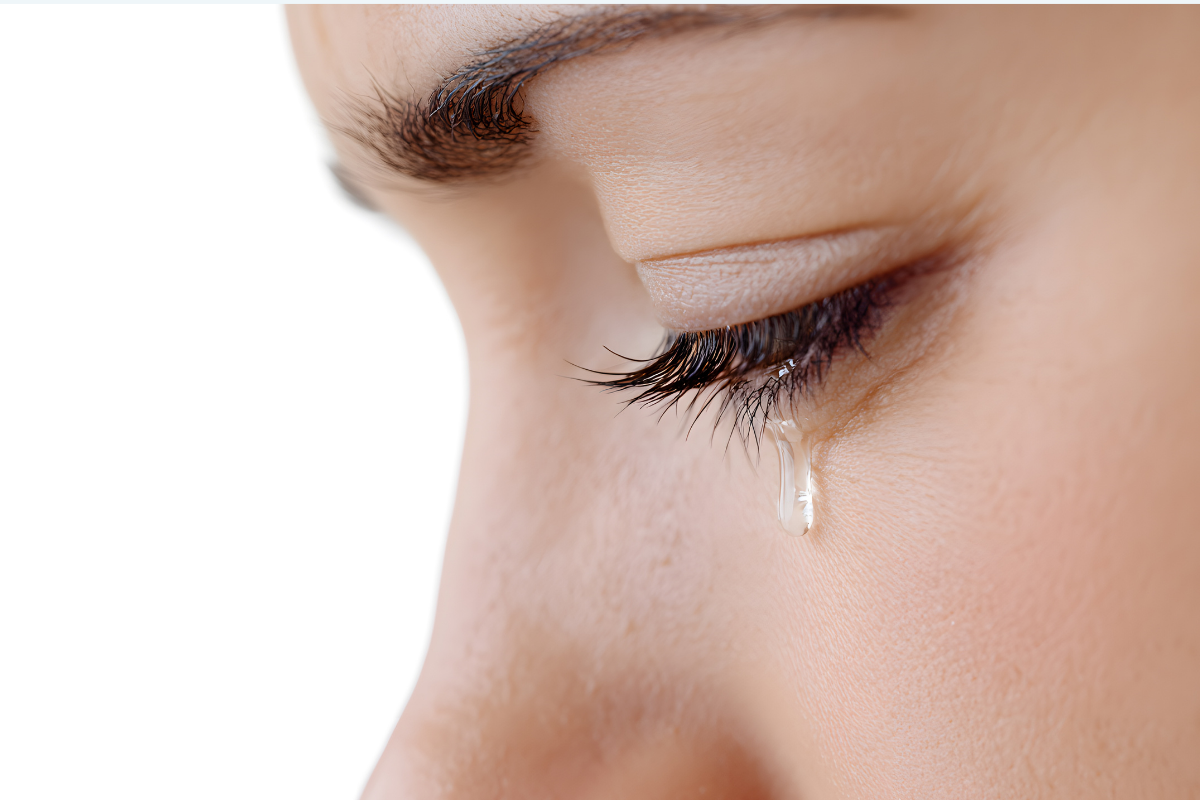 Close-up of an eye with a single tear.