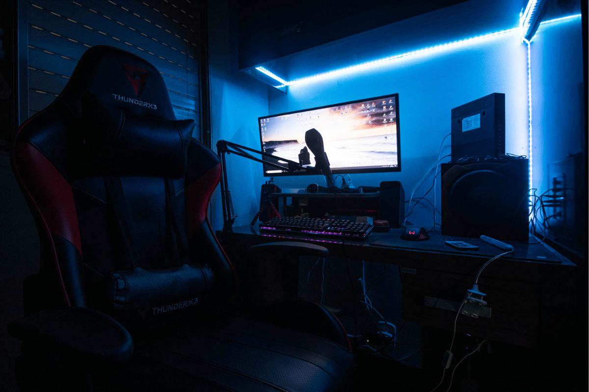 Dark gaming desk setup with blue LED lighting.