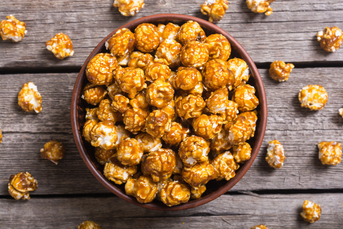 Bowl of miso caramel popcorn on wooden table.