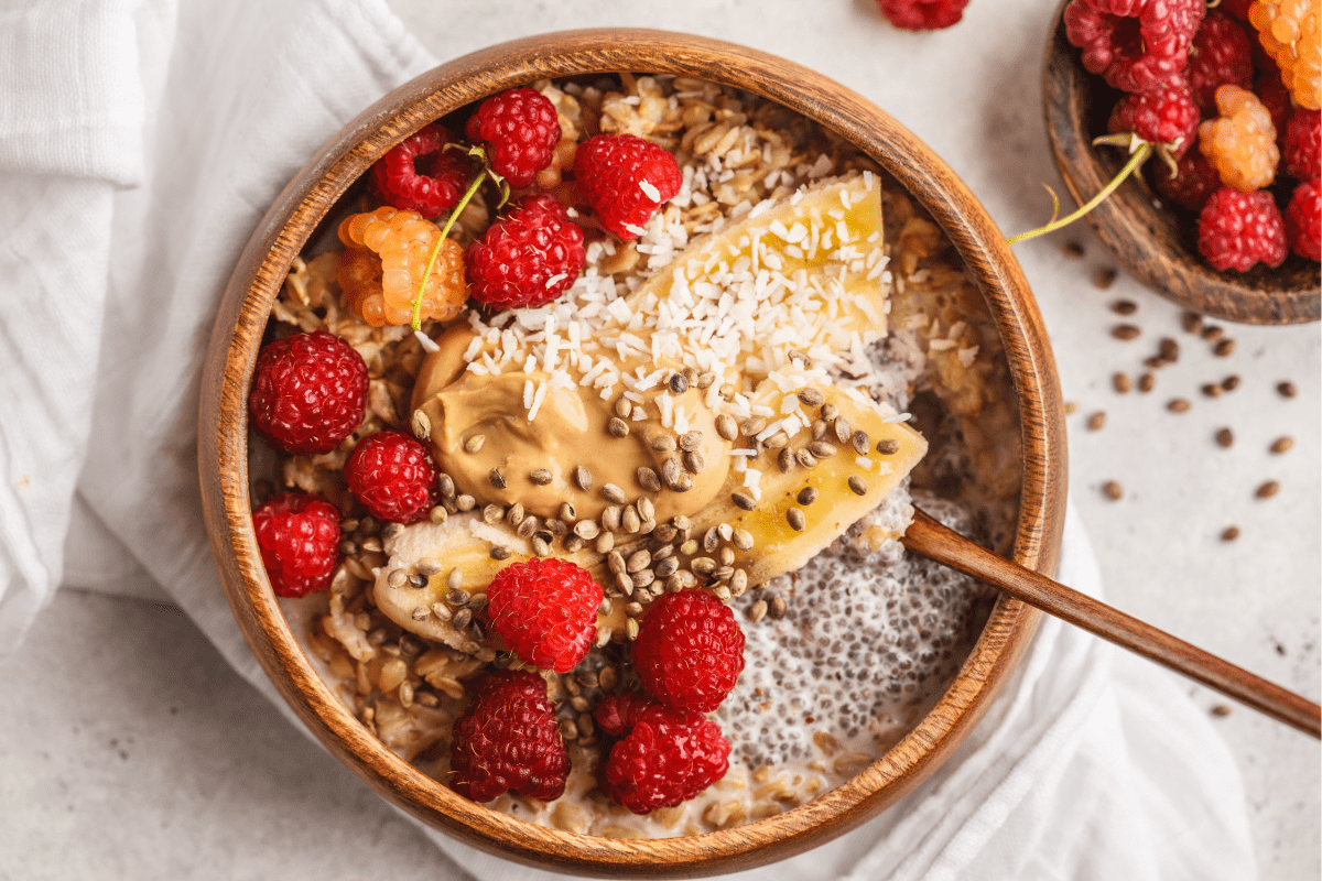 A bowl of creamy oatmeal topped with fresh raspberries.